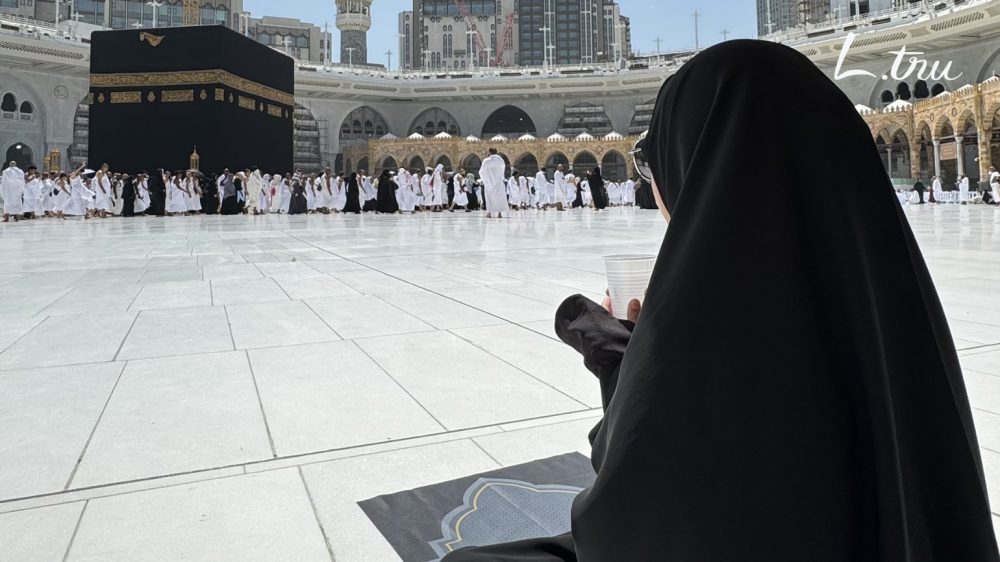 Jemaah wanita muslimah membaca doa dan berzikir mengenakan gamis ihram - panduan doa lengkap ibadah umroh dari ihram hingga tahallul